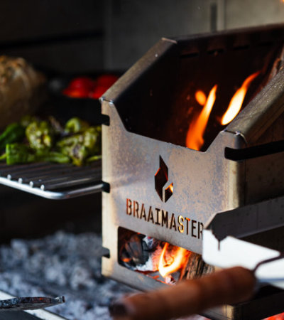 close up braaimaster logo op ijzeren bak met gegrilde groentes op achtergrond